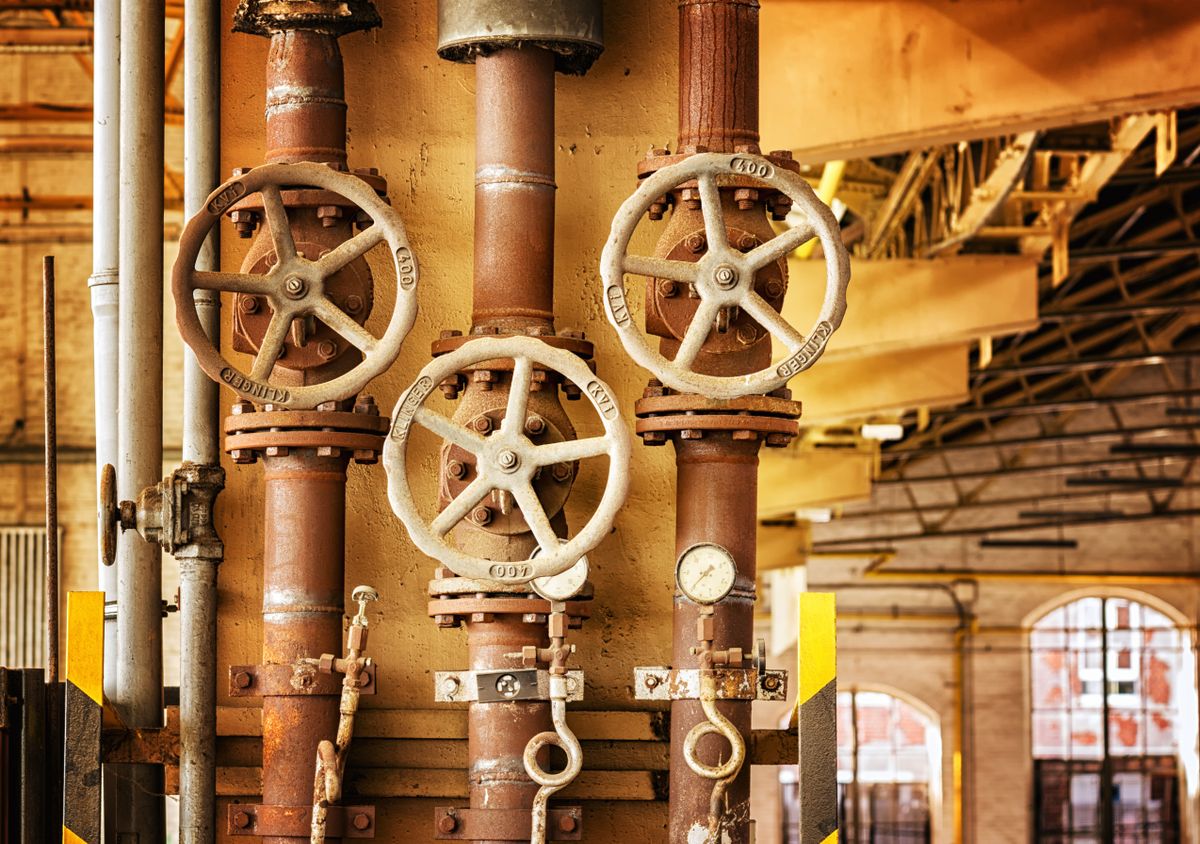 Hand-wheel valves on industrial pipework inside a plant