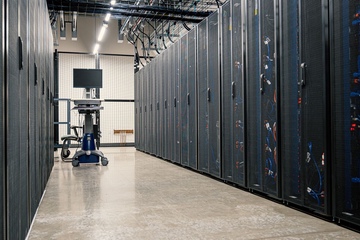 Cabled server racks lining the aisle of a data centre
