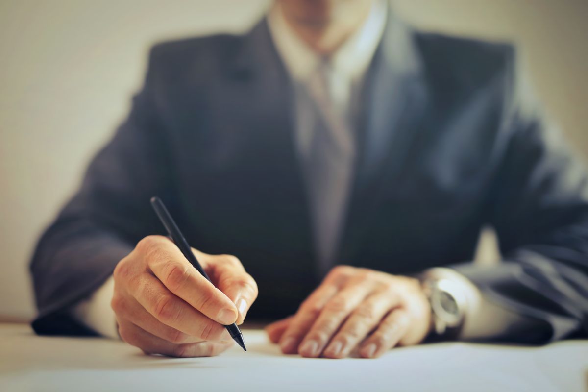 A contract being signed across an office desk